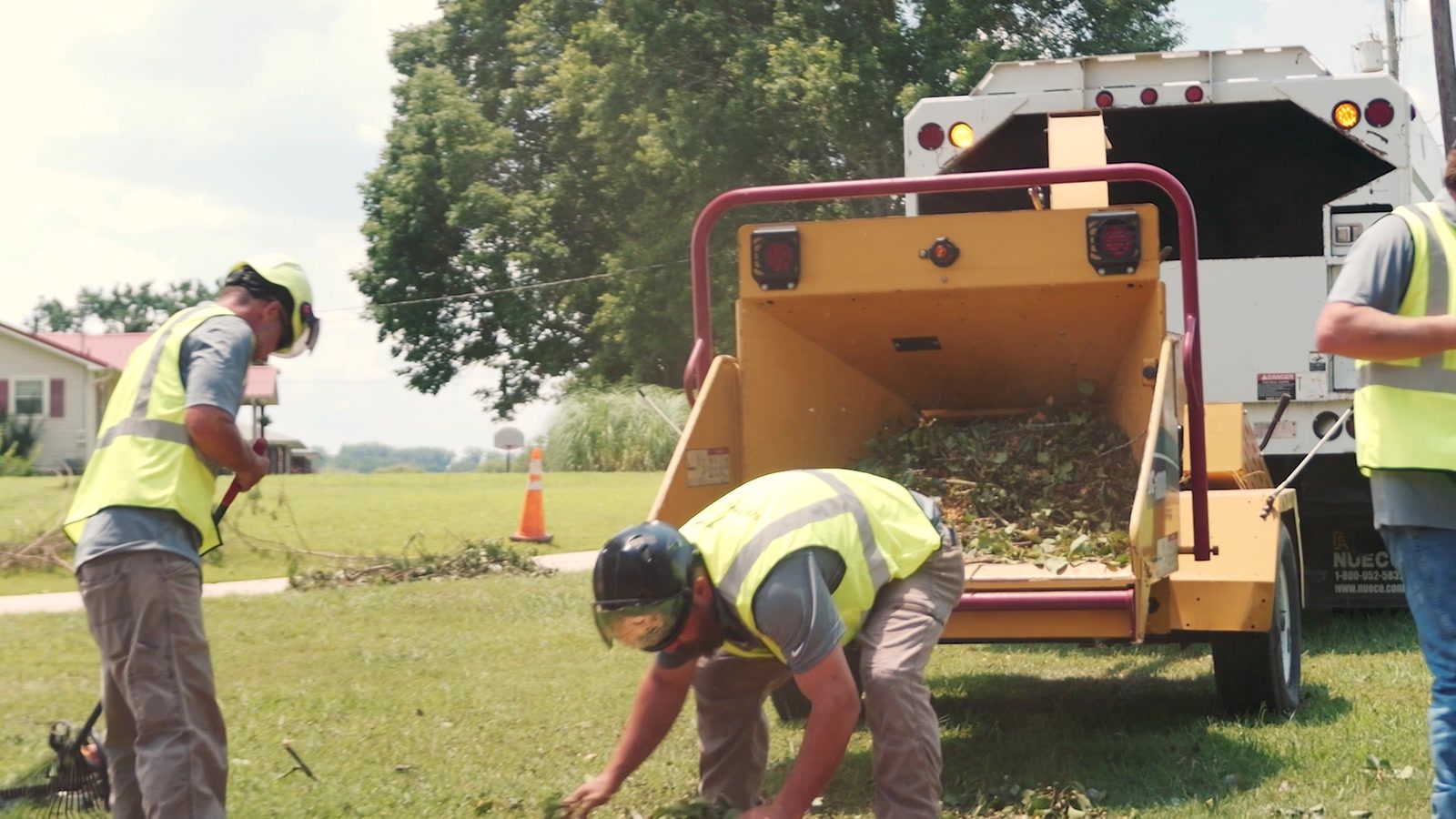 Southeastern Tree Pros crew raking and feeding the chipper on a residential job